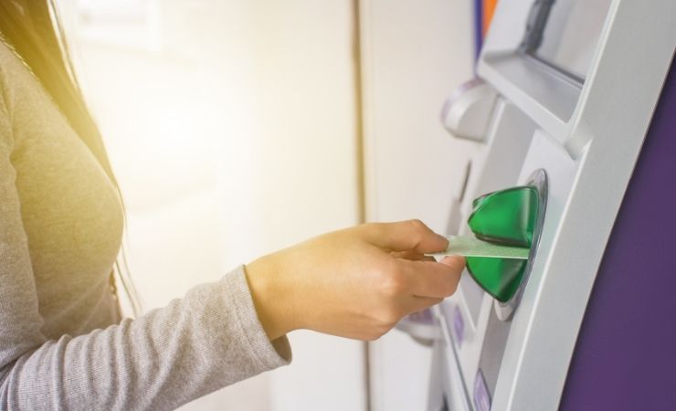 Donna inserisce carta sportello Atm