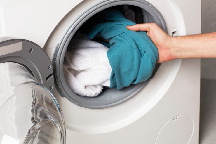 Donna che tira fuori il bucato pulito dalla lavatrice
