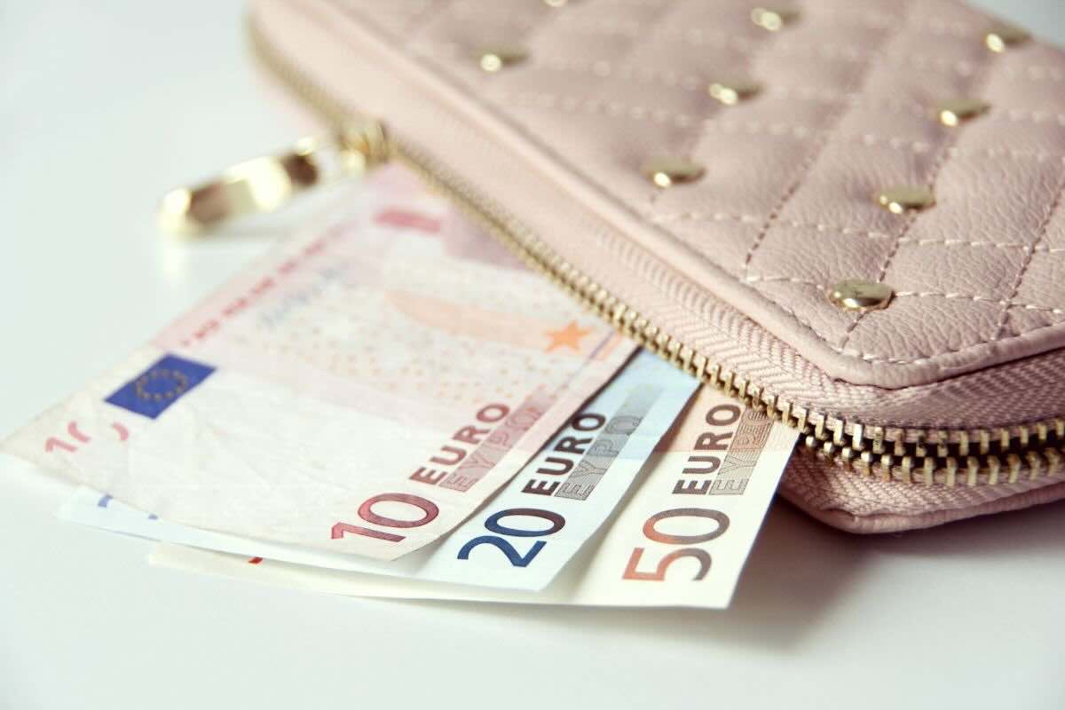 Portafoglio rosa con borchie, banconote in ordine da 50, 20 e 10 euro