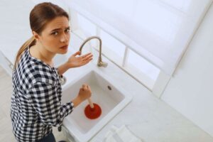 donna cerca di sturare lavandino